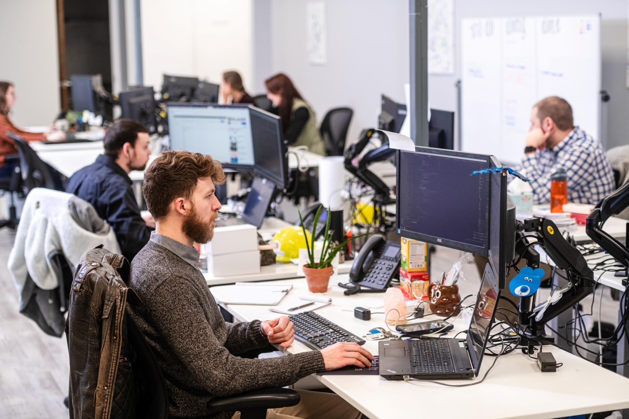 a group of people working at computers in an office space