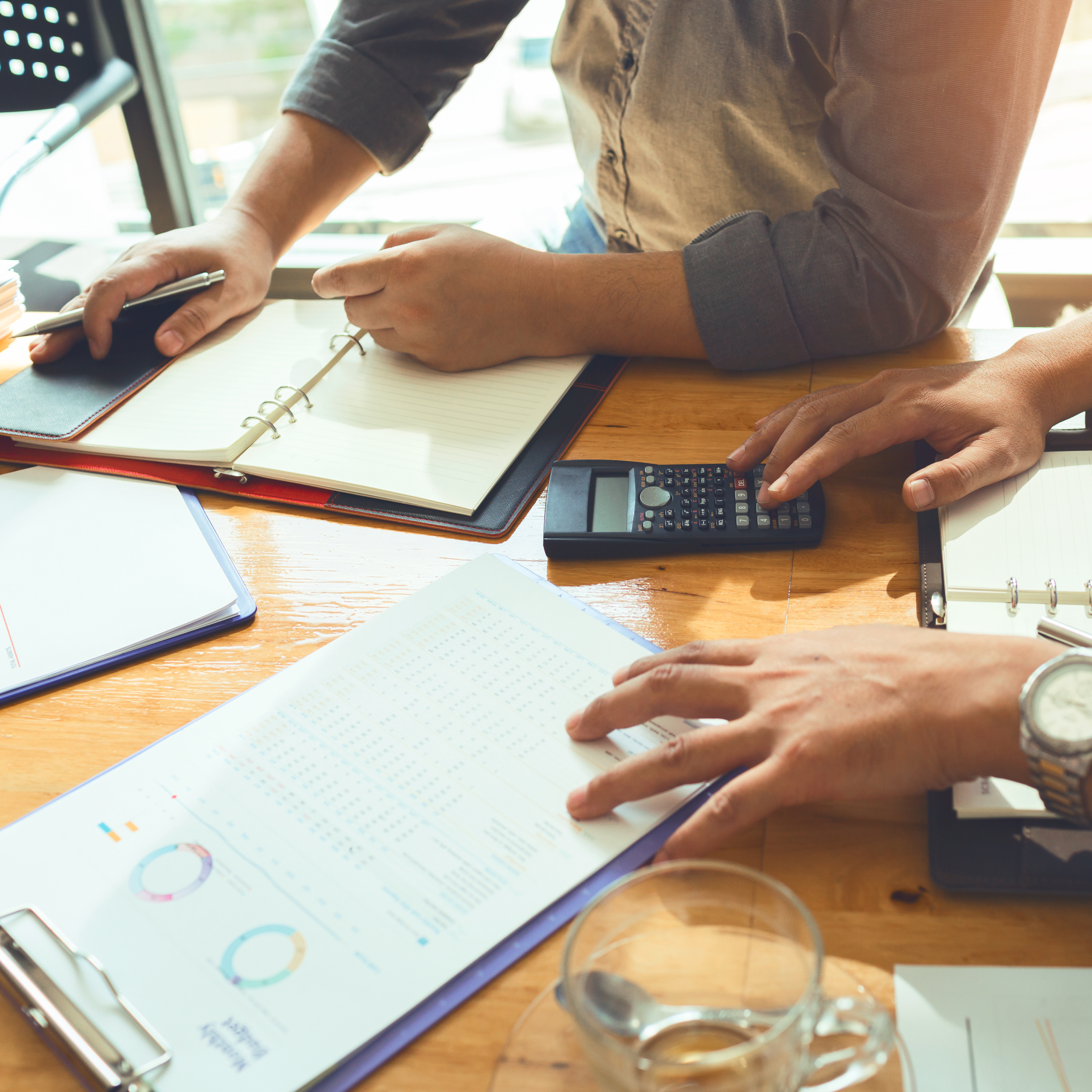 AI-In-Finance-3 Two business men looking over financial reports and struggling to understand why the AI numbers aren't accurate. The issue is the strategy in which the AI was deployed and the lack of cohesive integration across departments and team members.