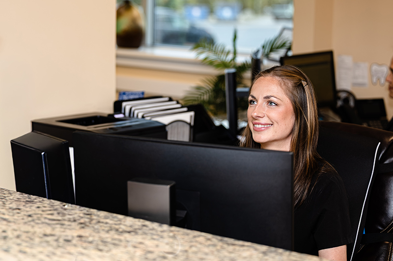 Office Manager Chelsea Miklich greets patients at the front desk in the Exeter Smiles Allentown, PA office.